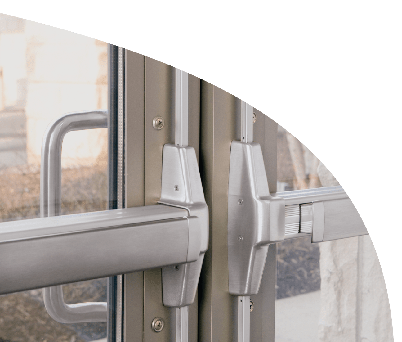 Glass double doors, zoomed in the two exit devices attached to them